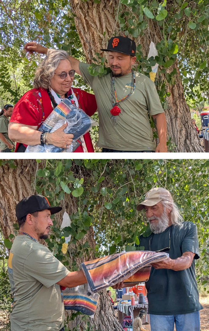 Festival organizer José Luis presents commemorative handwoven blankets to Dr. Ana Malinalli X Gutiérrez Sisneros and Don Bustos, who were honored as this year's Madrina del Ajo and Padrino del Ajo. The recognitions celebrate their enduring contributions to agriculture, food sovereignty, environmental stewardship, education, and the preservation of Northern New Mexico's cultural traditions. Festival organizer José Luis presents commemorative blankets to Dr. Ana Malinalli X Gutiérrez Sisneros and Don Bustos, honored as this year's Madrina del Ajo and Padrino del Ajo.